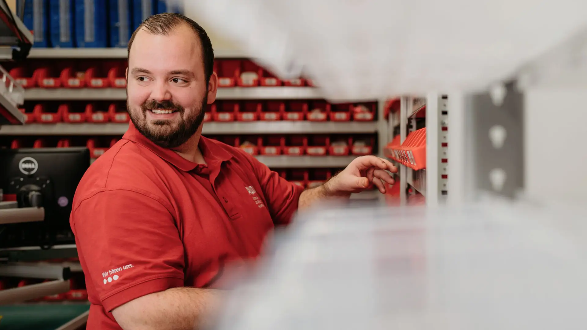 Ein lachender Mitarbeiter in der Logistik Abteilung